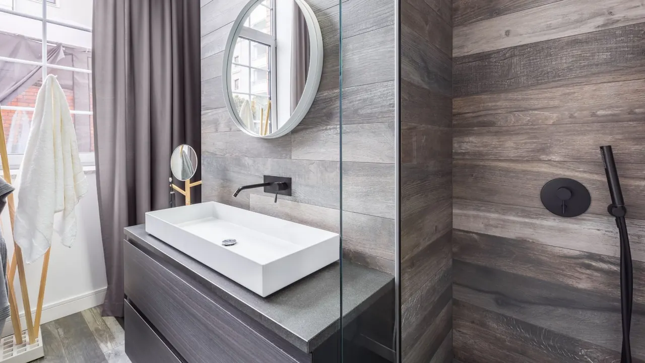 A freshly cleaned modern bathroom with a stone-topped vanity and walk-in shower