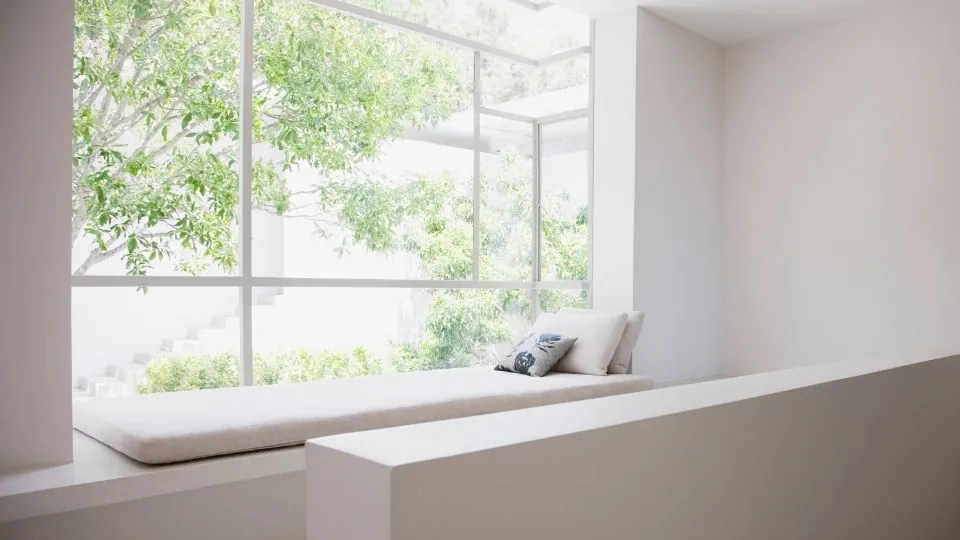 A bright, freshly cleaned living room with a window seat looking onto the garden