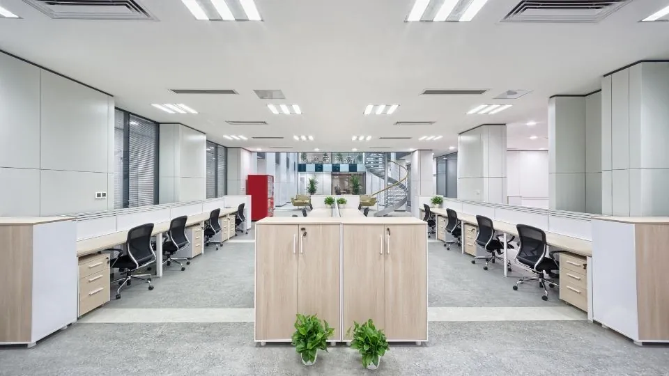 An open-plan office with rows of clean desks and polished floors